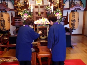誕生仏に甘茶を注ぐ。