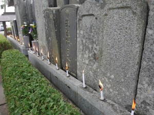 無縁墓の前に蝋燭を灯す