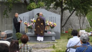 供養塔前にてお経をあげる